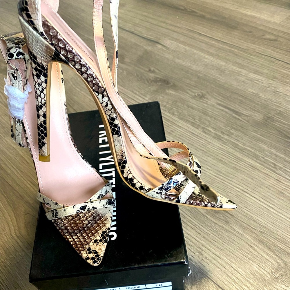 Strappy snake skin heels .